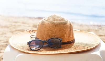 straw hat and black sunglasses at the beach