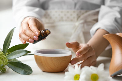 woman adding essential oil to diffuser