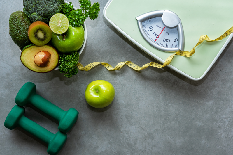 scale, measuring tape, green vegetables, and dumbbells