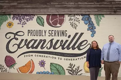 Proudly Serving Evansville mural with owners of Paul's Pharmacy