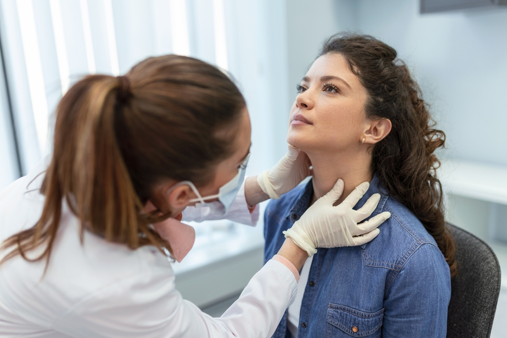 woman getting her thyroid examined