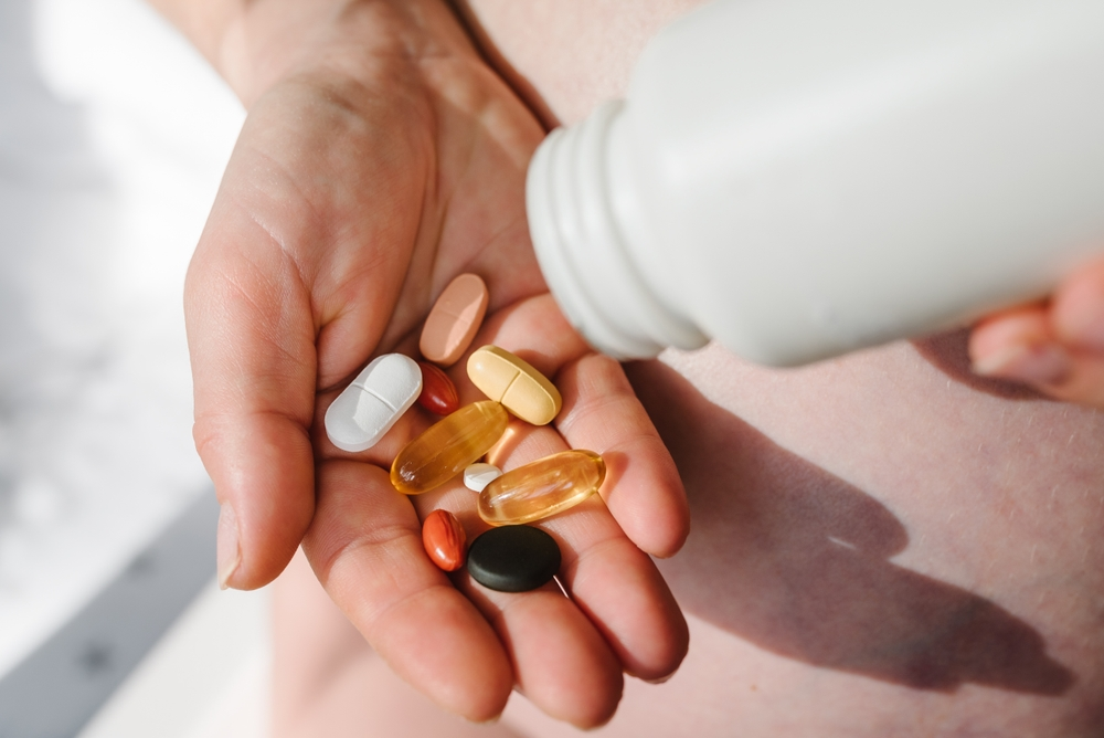 handful of various vitamins and supplements