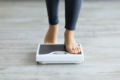 woman's feet stepping onto a scale