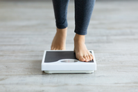 woman's feet stepping onto a scale